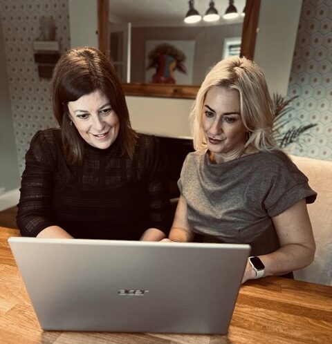 Helen and Katie from K and H Mortgages sitting together and looking at a laptop